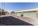 Exterior of the property with detached garages, tidy landscaping, and a well-paved driveway at 7111 N 63Rd Dr, Glendale, AZ 85301