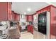 Well-lit kitchen with dark wood cabinets, mosaic backsplash, granite counters and stainless steel appliances at 7111 N 63Rd Dr, Glendale, AZ 85301