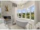 Luxurious bathroom with freestanding tub, marble accents, a fireplace, and large windows with a view at 7475 E Gainey Ranch Rd # 22, Scottsdale, AZ 85258