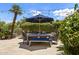 Inviting patio dining set with umbrella with seating for six surrounded by manicured greenery at 7475 E Gainey Ranch Rd # 22, Scottsdale, AZ 85258