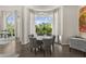 Elegant dining area with modern chandelier and verdant outdoor views through large arched windows at 7475 E Gainey Ranch Rd # 22, Scottsdale, AZ 85258
