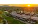 Expansive custom home with tile roof on lush golf course with pond and mountain views during colorful sunset at 7475 E Gainey Ranch Rd # 22, Scottsdale, AZ 85258