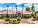 Stunning home exterior featuring lush landscaping, circular driveway, and stately palm trees at 7475 E Gainey Ranch Rd # 22, Scottsdale, AZ 85258