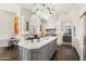 Open-concept kitchen featuring a large island, white cabinets, and pendant lighting at 7475 E Gainey Ranch Rd # 22, Scottsdale, AZ 85258