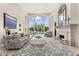 Elegant living room with large windows overlooking pool, fireplace, and stylish décor at 7475 E Gainey Ranch Rd # 22, Scottsdale, AZ 85258