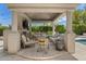 Charming outdoor living space with comfortable seating, a fireplace, and a view of the lush backyard at 7475 E Gainey Ranch Rd # 22, Scottsdale, AZ 85258
