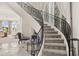 Elegant curved staircase with wrought iron railing, carpeted steps, and marble floors at 7475 E Gainey Ranch Rd # 22, Scottsdale, AZ 85258