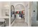 Spacious walk-in closet with custom shelving, vanity, dressing area, and marble floors at 7475 E Gainey Ranch Rd # 22, Scottsdale, AZ 85258