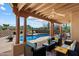 Covered back patio boasts lounge furniture, ceiling fan, and open access to pool area at 9030 E Trail Dr, Carefree, AZ 85377