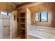 Well-lit bathroom with a soaking tub, separate shower, and built-in shelving at 9030 E Trail Dr, Carefree, AZ 85377