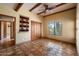Bedroom with beamed ceiling, tile floors, and a window overlooking the desert landscape at 9030 E Trail Dr, Carefree, AZ 85377