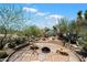Outdoor fire pit area with flagstone patio, seating, desert landscaping, and bright blue sky at 9030 E Trail Dr, Carefree, AZ 85377