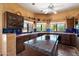 Kitchen with tile counters and backsplash, dark wood cabinets, and central island at 9030 E Trail Dr, Carefree, AZ 85377