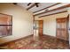 Large living room with terracotta tile, beamed ceiling, and multiple entryways at 9030 E Trail Dr, Carefree, AZ 85377