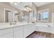 Elegant bathroom featuring dual sinks, a soaking tub, a shower, and plantation shutters for natural light control at 925 W San Marcos Dr, Chandler, AZ 85225