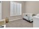 Bright bedroom featuring a crib, plush carpet, and plantation shutters to filter natural light at 925 W San Marcos Dr, Chandler, AZ 85225