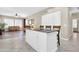 Open kitchen island with cooktop, seating and white cabinets flows into the living room for easy entertaining at 925 W San Marcos Dr, Chandler, AZ 85225
