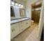 Bathroom featuring double vanity, granite countertop, framed mirrors and walk-in shower at 10101 N 91St Ave # 88, Peoria, AZ 85345