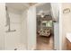 Accessible bathroom with a shower featuring grab bars and a view into a cozy bedroom with a quilt-covered bed at 1021 S Greenfield Rd # 1165, Mesa, AZ 85206