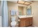 A bathroom with a toilet, a vanity with a wood cabinet, and a large mirror at 1021 S Greenfield Rd # 1165, Mesa, AZ 85206