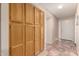 Hallway view of natural wood storage cabinets and decorative tile flooring at 1021 S Greenfield Rd # 1165, Mesa, AZ 85206