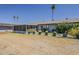 Backyard view showcases a covered patio area, mature landscaping, and an open lawn at 11135 W Cameo Dr, Sun City, AZ 85351