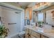 Bathroom featuring a shower with white tile, wood cabinets, and a marble countertop at 11135 W Cameo Dr, Sun City, AZ 85351