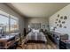 Cozy bedroom featuring a decorative accent wall, comfortable furnishings, and plenty of natural light at 11135 W Cameo Dr, Sun City, AZ 85351