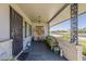 Inviting covered front porch with seating, decorative screens, and attractive tile flooring at 11135 W Cameo Dr, Sun City, AZ 85351