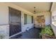 Inviting covered front porch with seating, decorative screens, and attractive tile flooring at 11135 W Cameo Dr, Sun City, AZ 85351