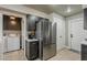 Stainless steel refrigerator and cabinets are close to a laundry area in this well designed kitchen at 11135 W Cameo Dr, Sun City, AZ 85351