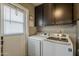Efficient laundry room featuring a modern washer and dryer set and upper cabinets for storage at 11135 W Cameo Dr, Sun City, AZ 85351