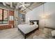 Bedroom with exposed brick, concrete ceilings, and stylish furnishings at 114 W Adams St # 202, Phoenix, AZ 85003