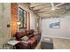 Living room showcasing exposed brick, concrete ceilings, and a stylish leather sofa at 114 W Adams St # 202, Phoenix, AZ 85003