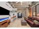 Spacious living area with exposed brick, industrial ceiling, connected bar seating, and modern furnishings at 114 W Adams St # 202, Phoenix, AZ 85003