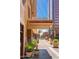 Street view featuring the building entrance, lush planters, and downtown cityscape in the background at 114 W Adams St # 202, Phoenix, AZ 85003
