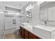 Bright bathroom features a double sink vanity, framed mirrors, and tiled shower and tub at 1201 E Campbell Ave, Gilbert, AZ 85234