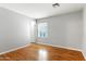 Bright bedroom with a window, light hardwood floors, and neutral gray paint at 1201 E Campbell Ave, Gilbert, AZ 85234