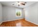 Empty bedroom with light hardwood floors, plantation shutters, and a ceiling fan at 1201 E Campbell Ave, Gilbert, AZ 85234