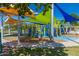 Bright and colorful playground with multiple climbing structures, slides, and shaded seating areas at 1201 E Campbell Ave, Gilbert, AZ 85234