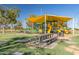 Community playground shaded by a bright yellow awning, with picnic tables for gathering with friends at 1201 E Campbell Ave, Gilbert, AZ 85234