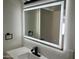 Illuminated bathroom mirror above a vanity with black fixtures and white countertops, creating a bright and modern space at 1309 E Julie Dr, Tempe, AZ 85283
