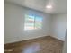 Bright bedroom featuring wood-look flooring and a large window with neighborhood views at 1309 E Julie Dr, Tempe, AZ 85283