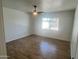 Bedroom featuring wood-look flooring, ceiling fan, and neighborhood view through large window at 1309 E Julie Dr, Tempe, AZ 85283