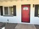 Inviting front entrance featuring a red door, white brick, and dark shutters for a striking contrast and curb appeal at 1309 E Julie Dr, Tempe, AZ 85283
