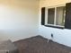 View of the front porch showcasing white brick and dark shutters, complemented by a gravel bed for a clean design at 1309 E Julie Dr, Tempe, AZ 85283