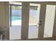 View through the white patio doors to the sparkling swimming pool and outdoor area at 1309 E Julie Dr, Tempe, AZ 85283