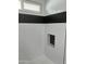 Modern shower with sleek white tile, black accent stripe, and convenient inset shelving at 1309 E Julie Dr, Tempe, AZ 85283