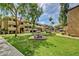 Beautiful courtyard with landscaped grounds, mature trees, and seating areas within a condo community at 1331 W Baseline Rd # 167, Mesa, AZ 85202