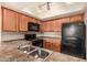 Bright kitchen offering double stainless sink, updated black appliances, and warm cabinets at 1331 W Baseline Rd # 167, Mesa, AZ 85202